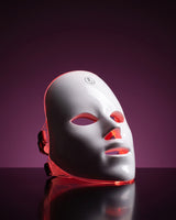 GAIA HALO LED mask lit in red light mode on a deep plum background