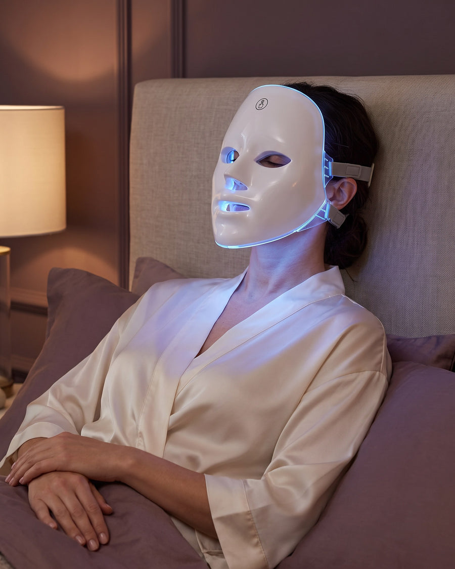 Woman wearing the GAIA HALO LED mask in blue light mode during an evening routine