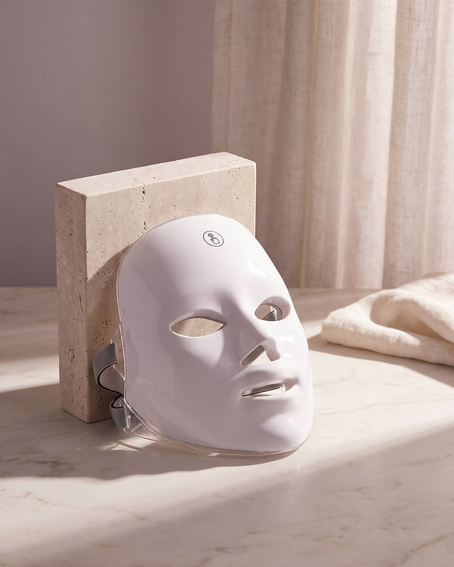 GAIA HALO LED mask switched off, resting on travertine and marble